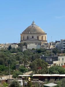 a building on top of a hill with buildings at Mosta Garden Studio in Mosta