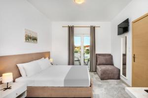 1 dormitorio con 1 cama grande y 1 silla en Nikiforos Village, en Chaniotis