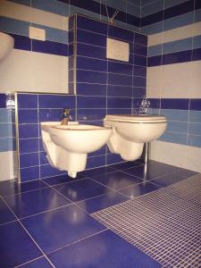 Baño de azulejos azules con 2 aseos y lavamanos en Bed And breakfast Il Ghiro en Cedrasco