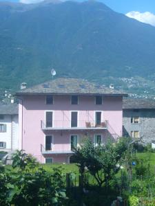 um edifício rosa em frente a uma montanha em Bed And breakfast Il Ghiro em Cedrasco