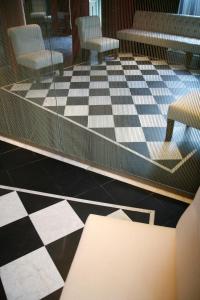 a room with chairs and a checkerboard floor at Hotel Piccolo Portofino in Portofino