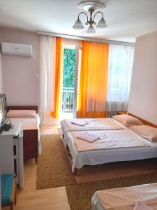 1 dormitorio con 2 camas y ventana en Bendegúz Villa en Balatonföldvár