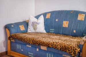 eine blaue Couch mit zwei Kissen drauf in der Unterkunft Apartment Schwalbennest in Mühlbach