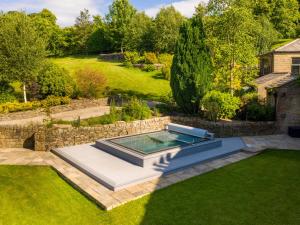 een uitzicht over een zwembad in de tuin bij Moorlands Manor in Colne