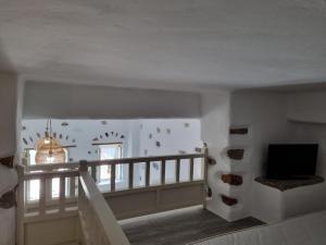 Pokój ze schodami, telewizorem i oknem w obiekcie Nikola's place II w mieście Astypalea