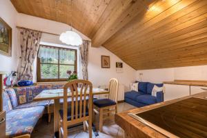 a living room with a table and a blue couch at Apartment Waldesruh in Mühlbach