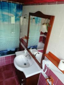 y baño con lavabo blanco y espejo. en Hostería Casa Flor, en Murias de Rechivaldo