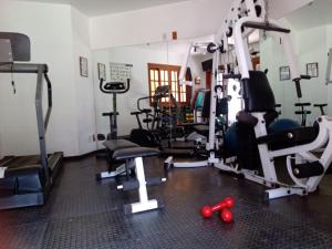 a gym with several tread machines and red weights at Pousada Canto da Paz in Petrópolis