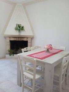 a white table with white chairs and a fireplace at La Casa di Tagliacozzo delizioso appartamento centrale con 2 camere e camino in Tagliacozzo