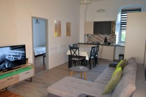 a living room with a couch and a tv and a kitchen at Apartman Volare in Vodnjan