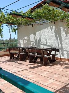 a picnic table and benches on a patio at Risveglio sull'Etna in Belpasso