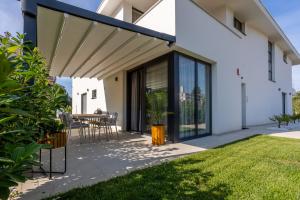 une maison blanche avec un auvent sur une terrasse dans l'établissement Villa Piano, à Vantačići