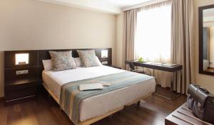 a hotel room with a bed and a window at Sercotel Aura Algeciras in Algeciras