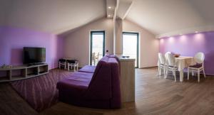 a living room with purple walls and a couch and a table at Apartments Ponta Krasici in Tivat
