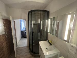 a bathroom with a shower and a white sink at Appartement en face de la plage avec barbecue in Plage dʼArgelès