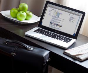 a laptop computer sitting on a desk with a plate of apples at Sercotel Aura Algeciras in Algeciras +41 photos