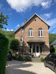 een bakstenen huis met een auto ervoor geparkeerd bij Gîte la mosane in Profondeville