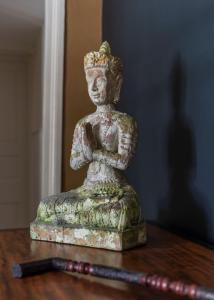 a statue sitting on top of a wooden table at La Maison Pavie in Dinan