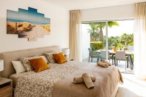 een slaapkamer met een bed met twee teddyberen erop bij Alcazaba Lagoon Apartment with Private Beach, Pools, Gym, Sauna, Hot Tub & Fully Equipped Kitchen in Casares