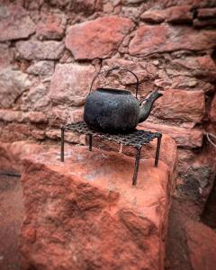 a tea kettle sitting on a stand on a stone wall at Cuesta de san miguel in Chilecito