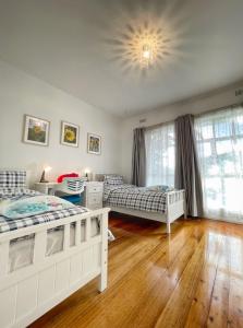 a bedroom with two beds and a window at Cozy and stylish 3 bedroom home in Mentone in Mentone