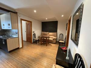 a kitchen and living room with a couch and a table at Casa Enmedio in Iznatoraf
