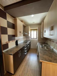 cocina grande con armarios de madera y fregadero en Casa Enmedio, en Iznatoraf