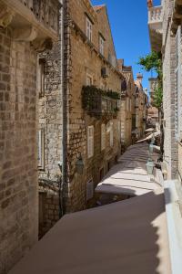 een steegje in een oude stad met stenen gebouwen bij Studio Nikol in Dubrovnik