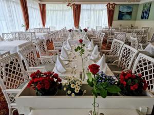 un comedor con mesas blancas y sillas con flores en Olden Fjordhotel, en Olden