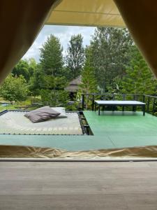 a bed on a patio with a picnic table at khaokho keree tara in Khao Kho