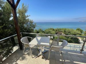 a table and chairs on a balcony with the ocean at Horizon Beach Hotel in Plakias
