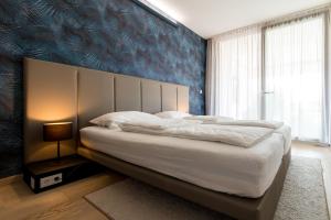 a bedroom with a large bed with a blue wall at Villa Piano Residences in Vantačići