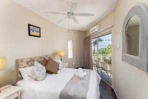 a bedroom with a bed and a balcony at Casablanca 6 in Ballito