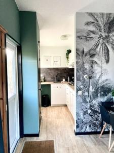 a kitchen with a palm tree mural on the wall at Holiday home Beachy Days near ocean & lake in Noordwijkerhout