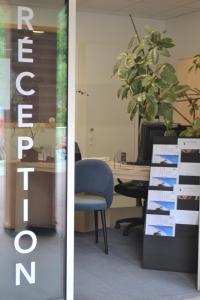 un bureau avec une chaise et un bureau avec une usine dans l'établissement Résidence Eureca, à Brides-les-Bains