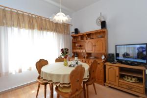 a dining room with a table with chairs and a television at Apartment Boris 2161 in Pula