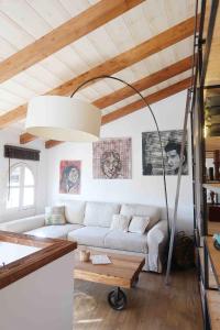 ein Wohnzimmer mit einem weißen Sofa und einer Lampe in der Unterkunft Qué bueno que viniste. Edificio singular in Plasencia