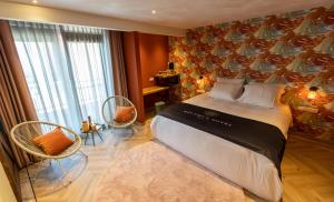 a bedroom with a large bed and two chairs at Boutiquehotel Dokkum in Dokkum
