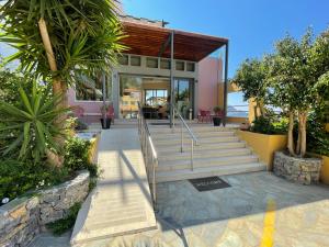 a house with a staircase in front of it at Horizon Beach Hotel in Plakias