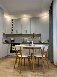 een keuken met witte kasten en een tafel en stoelen bij NOVA lake apartamente wild jungle in Satu Mare