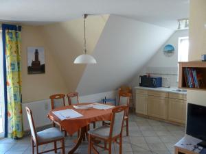 a kitchen with a table and chairs in a room at Ferienwohnung Ankerplatz_VOLB in Ostseebad Karlshagen