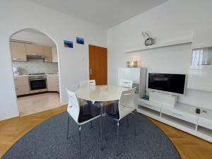 kuchnia i jadalnia ze stołem i krzesłami w obiekcie Apartment Marohnić w mieście Malinska