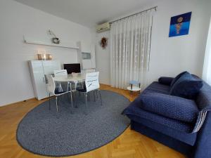 salon z niebieską kanapą i stołem w obiekcie Apartment Marohnić w mieście Malinska