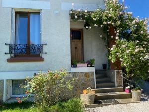 una casa con escaleras y una puerta con flores en Chambre du Petit Prince, en Chaville
