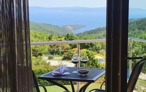 - un balcon avec une table et deux verres de vin dans l'établissement Casa Grande - Violette, Silver and Golden apartments with park and sea view, à Labin