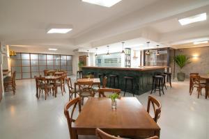 a restaurant with wooden tables and chairs and a bar at EKO HOTEL in Presidente Prudente