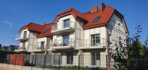 a large building with a red roof at Apartamenty Wrzosowa in Dębki