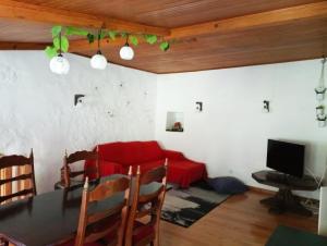 een woonkamer met een tafel en een rode bank bij Casa do Rio in Coimbra