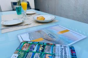 a stack of magazines sitting on top of a table at La Perle Marine 3 in Le Grau-du-Roi