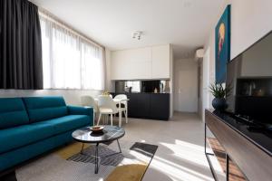 a living room with a blue couch and a table at Villa Piano Residences in Vantačići